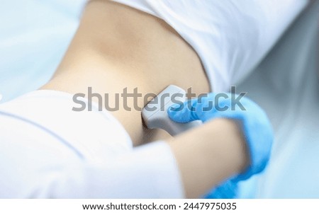 Doctor makes ultrasound diagnosis of patient with kidney prolapse. Ultrasound scanning and examination of abdominal cavity Royalty-Free Stock Photo #2447975035