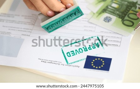 Approved EU visa application and cash euro banknotes. Obtaining visa to Europe and moving to European country Royalty-Free Stock Photo #2447975105