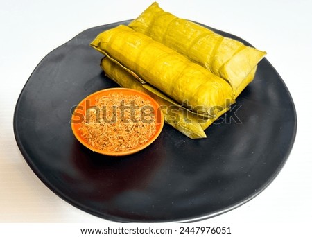 Burasa or Buras is an Indonesian rice dumpling from South Sulawesi, cooked with coconut milk packed inside a banana leaf pouch Royalty-Free Stock Photo #2447976051