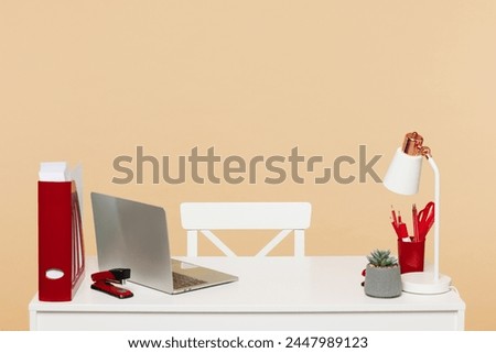 Empty modern office with wooden design white desk, lamp, red folder for documents, pc laptop computer with nobody working there isolated on plain wall yellow color background. Workplace career concept
