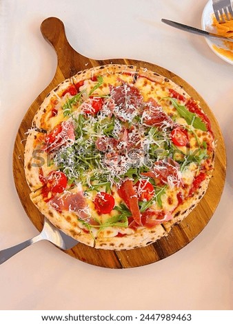 pizza with prosecciutto and arugula on top