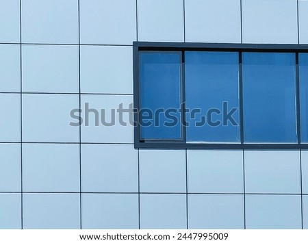 Contemporary Facade Design. Square Pattern and  blue window frames in Modern Building Wall. New architecture, under development.
