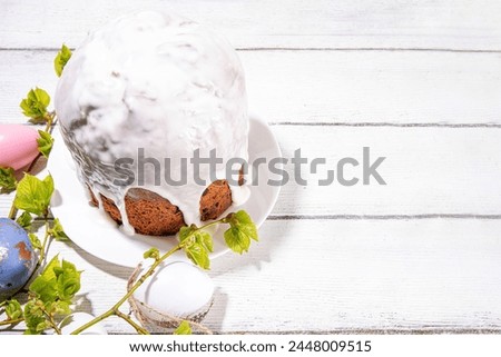 Easter orthodox catholic Christian  holiday background, with wooden cross symbol of religion, baking Easter cake with sugar icing, colored painted eggs and spring branches with blossoming leaves