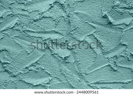 Abstract drawing on plastered wall. Toned in color Tidewater Green, background, texture. Copy space. Selective focus. Royalty-Free Stock Photo #2448009561