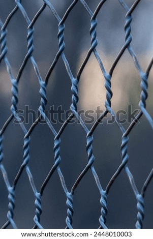 Close up photo of an elevated Platform Tennis, Paddle Ball courts chicken wire fence.