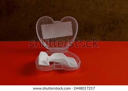 White sports mouthguard in opened packaging.