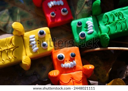 Toy monsters lie on autumn leaves. Halloween decorations.