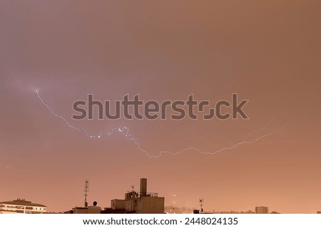 Lightning in a dark gray sky during a storm. Dramatic sky