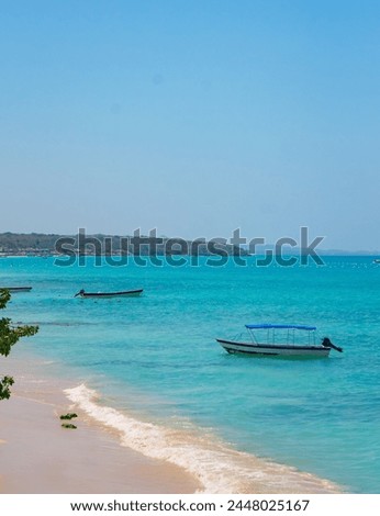 Scenic view of Playa Blanca in Baru, Cartagena, Colombia with clear turquoise waters, boats, and sandy beach under a blue sky Royalty-Free Stock Photo #2448025167