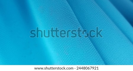 Wavy light blue crepe chiffon, in diagonal folds (macro, texture).