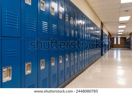 Empty school hallway with blue metal student lockers	 Royalty-Free Stock Photo #2448080785