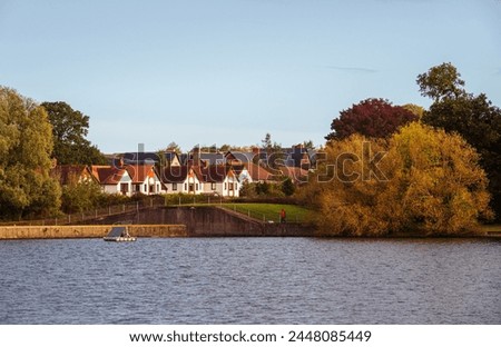 A landscape with freshwater and residential area on lakeside in Autumn colours Royalty-Free Stock Photo #2448085449