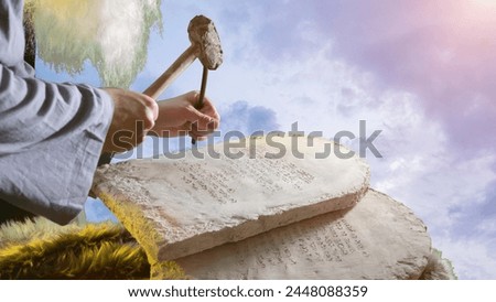 The biblical prophet Moses carves letters from stone on stone tablets of the Ten Commandments Royalty-Free Stock Photo #2448088359