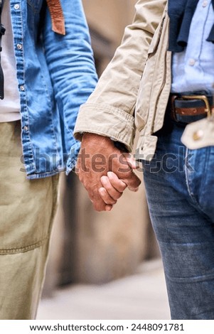 Vertical. Close up portrait of unrecognizable mature couple holding hands standing outdoor. Anonymous tourist adult people enjoying their vacation. Relationship and travel concept