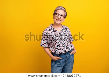 Photo of attractive pensioner woman look interested empty space wear trendy leopard print clothes isolated on yellow color background
