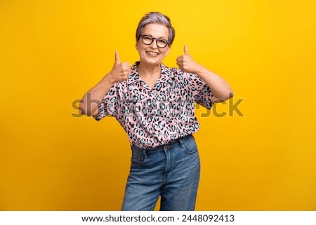 Photo portrait of pretty retired female show double thumb up dressed stylish leopard print outfit isolated on yellow color background