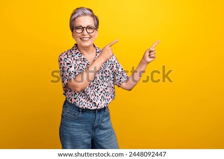 Photo portrait of attractive pensioner woman point empty space poster wear trendy leopard print clothes isolated on yellow color background
