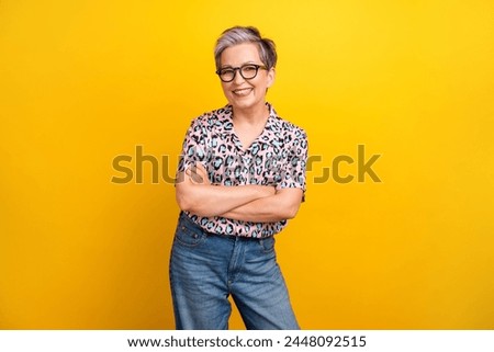 Photo portrait of pretty retired female crossed hands confident dressed stylish leopard print outfit isolated on yellow color background
