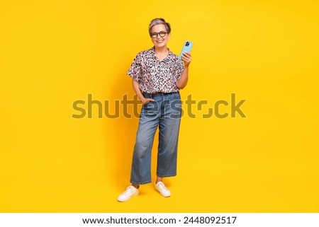 Full size photo of pretty retired female hold telephone ecommerce wear trendy leopard print outfit isolated on yellow color background
