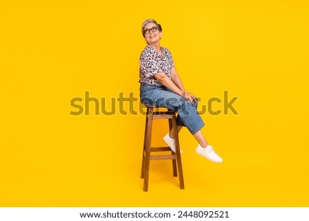 Full length photo of lovely senior lady wooden chair look empty space wear trendy leopard print garment isolated on yellow color background
