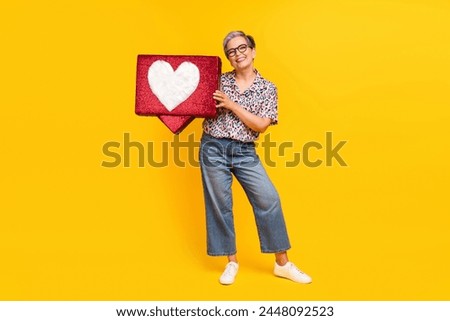Full length photo of lovely senior lady hold heart icon social media wear trendy leopard print garment isolated on yellow color background