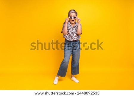 Full length photo of lovely senior lady shocked take off sunglass dressed stylish leopard print garment isolated on yellow color background