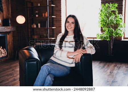 Photo of lovely young woman sit armchair relaxed wear striped outfit interior home living room in brown warm color