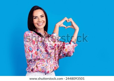 Photo of adorable pretty lady dressed print blouse showing arms heart emtpy space isolated blue color background