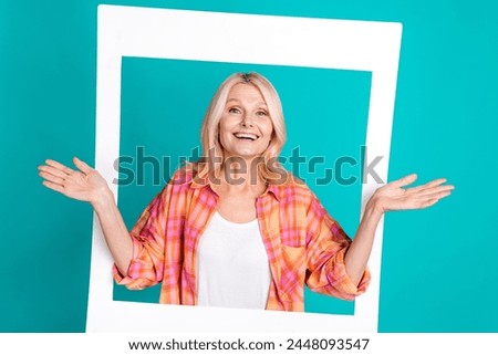 Portrait of charming lovely retired woman wear plaid trendy clothes hands hold photo card image isolated on cyan color background
