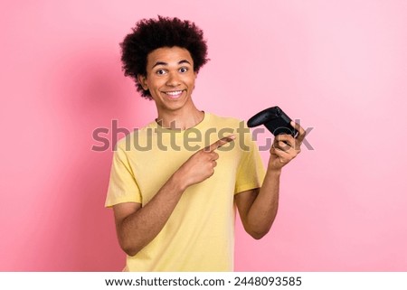 Photo of excited cheerful guy dressed yellow t-shirt pointing finger playstation joystick isolated pink color background