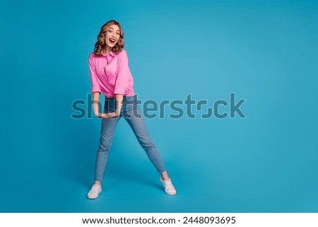 Full body photo of pretty young girl girlish dancing have fun wear trendy pink outfit hairdo isolated on blue color background