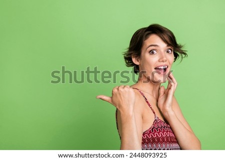 Photo of astonished nice girl wear trendy clothes presents wow sale news empty space isolated on green color background