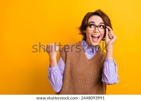 Portrait of excited woman wear knit waistcoat touch glasses indicating look at sale empty space isolated on yellow color background
