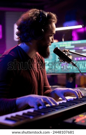Sound engineer playing piano keyboard to compose new music, singing on microphone and adding audio effects in post production. Artist composer creating songs for music industry.