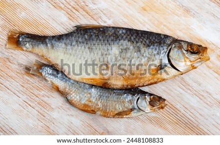Dried salted roach fish on wooden table, top view