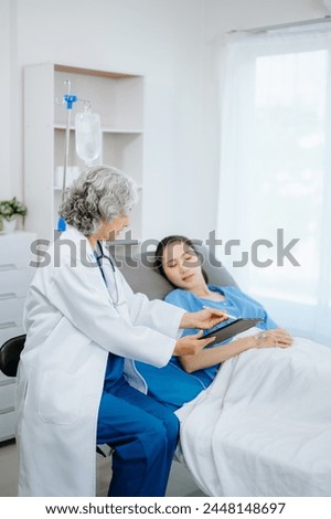  Doctor and young Female patient who lie on the bed while checking pulse, consult and explain with nurse taking note in hospital wards.
