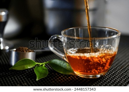 Pictures of barista pouring hot tea to glass on bar mat. Concept photos of beverage.
