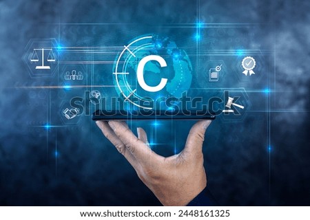 Copyright or patent concept,business concept. Businessman holding a smartphone computer with VR screen copyright icon background.