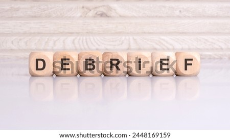 wooden cubes displaying the word 'Sponsor' arranged on a glossy gray surface, with a reflection and wooden background