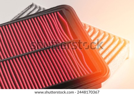 Red paper car engine air filter close-up. Filter for Cleaning the Airflow of Motra Machine. Concept to protect the engine from dust, dirt and moisture during operation. Close-up, toned studio photo.