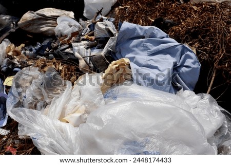 Plastic waste and fabric scraps that are difficult to decompose Being abandoned in public places is an environmental problem in urban communities. Industrial zones in 3rd world countries
 Royalty-Free Stock Photo #2448174433