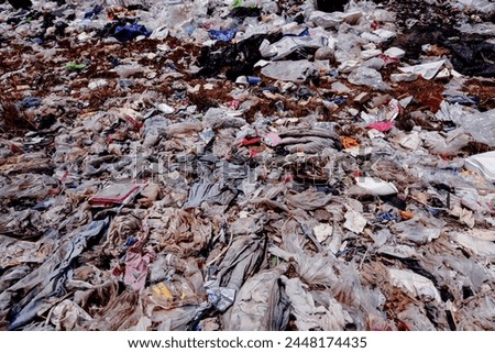 Plastic waste and fabric scraps that are difficult to decompose Being abandoned in public places is an environmental problem in urban communities. Industrial zones in 3rd world countries
 Royalty-Free Stock Photo #2448174435