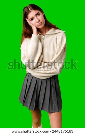 Young Woman Looking Bored and Disinterested Against Green Background