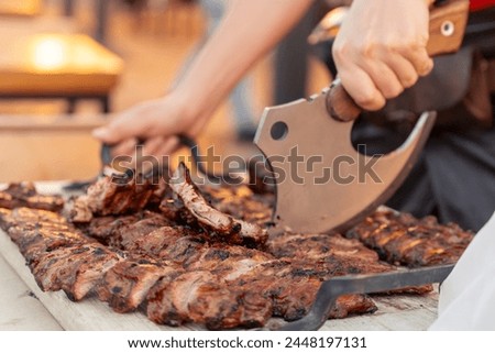 Meat ribs on fire, chopped with a kitchen hatchet