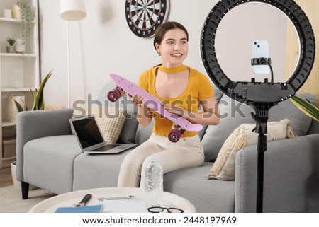 Female student with skateboard streaming online at home
