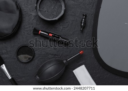 Different camera cleaning tools on concrete background, top view
