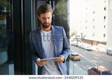 Business man, tablet and career on office balcony for web project, occupation review online and email feedback on digital report. Young male person or editor and tech for internet research on mockup