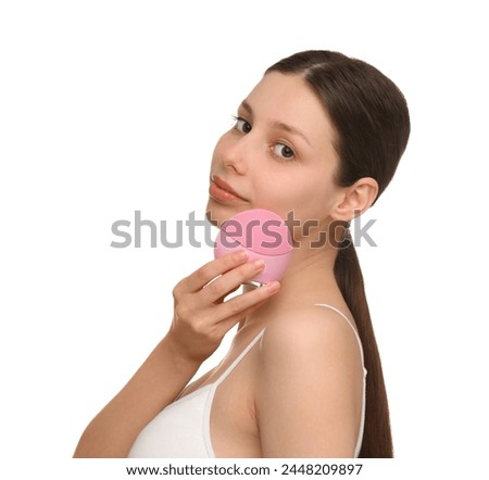 Washing face. Young woman with cleansing brush on white background