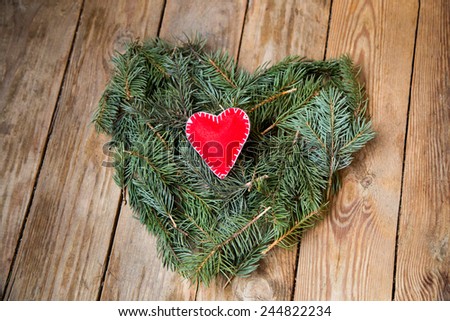pine heart and red textile heart on wooden background