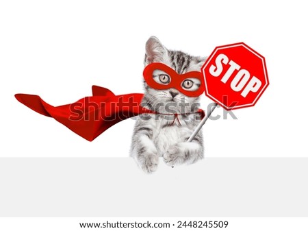 Cute kitten wearing superhero costume showing stop sign above empty white banner. Isolated on white background